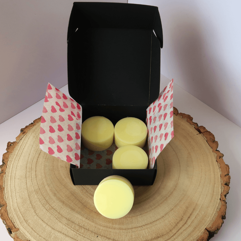 Spring Meadow Wax Melt inside an open black box, sitting on top of a wooden board.
