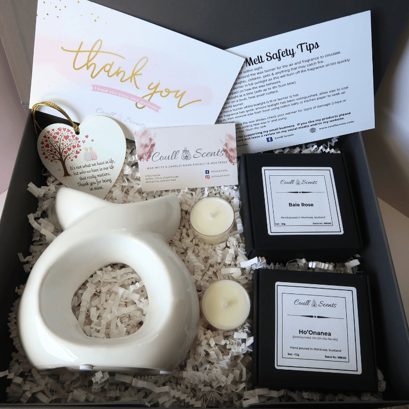Wax Melt Gift Set showing Serenity Wax Melt Burner, heart message plaque, 2 boxes of Wax Melts and 2 tealights, sitting on shredded paper in a grey box.
